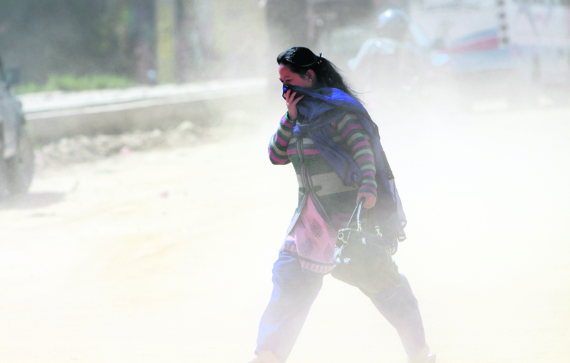 Pedestrians pass through a dusty road at satdobato.jpg